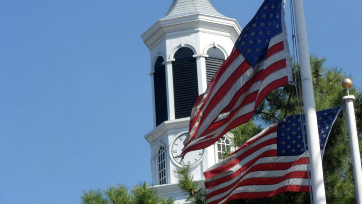 American flag hang with Presbyterian church steeple in background